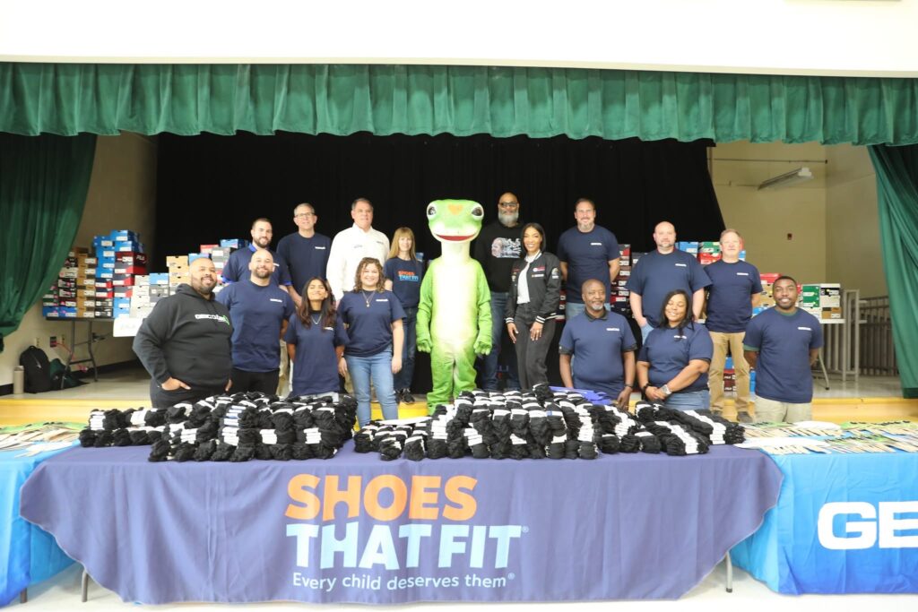 Representatives from the Wendell Scott Foundation, Shoes That Fit, and GEICO gather together at Oakdale Elementary in Charlotte, NC, to celebrate a special shoe giveaway event. This partnership provided 515 students with brand-new athletic shoes, honoring the legacy of NASCAR trailblazer Wendell Scott during Black History Month. The initiative highlights the power of community support and corporate philanthropy in uplifting young students and ensuring they have the resources they need to thrive.